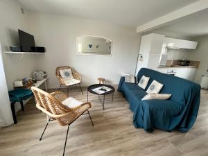 a living room with a blue couch and chairs at Gîte Au Coeur d’Azay in Azay-le-Rideau