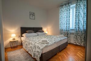 a bedroom with a large bed with blue curtains at Apartman Plitvice Happy Home in Plitvička Jezera
