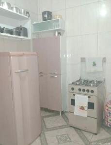 een witte keuken met een fornuis en een koelkast bij Casa em Diamantina in Diamantina
