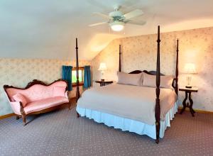 a bedroom with a large bed and two chairs at Rose Farm Inn in New Shoreham