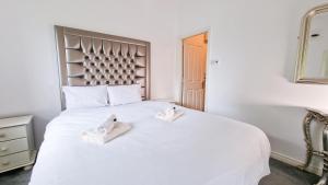um quarto com uma cama branca com sapatos brancos em Stylish 3 Bedroom House em Galway