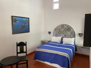 a bedroom with a bed and a table and a chair at Casa Yollotzin in Ajijic