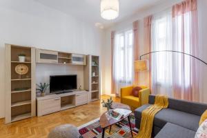 uma sala de estar com um sofá e uma televisão em Central Gozsdu Apartment in the Party Street em Budapeste