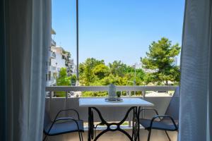 a white table and chairs on a balcony with a view at H Experience - Funky 1BD apartment in vibrant Nea Smirni in Athens