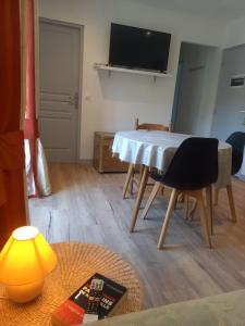 a living room with a table and a television at LA DOVA MARMOTTE in Brides-les-Bains