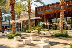 a building with palm trees and benches in front of it at Palm Springs BLUE DESERT Condo! in Palm Springs