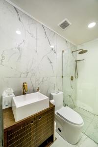 a white bathroom with a sink and a toilet at Palm Springs BLUE DESERT Condo! in Palm Springs