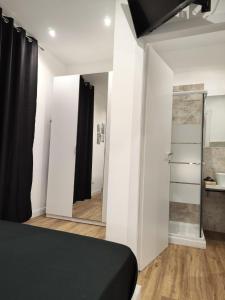 een slaapkamer met een zwart bed en een spiegel bij Moderno appartamento Cornelia-San Pietro con Giardino in Rome