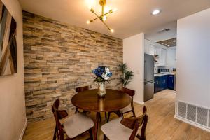 a dining room with a table and chairs and a brick wall at Palm Springs BLUE DESERT Condo! in Palm Springs