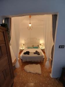 1 dormitorio con 1 cama con dosel blanco en LA CASA AZUL, en Chelva