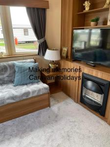 a living room with a tv and a fireplace at Making Memories Holiday Caravan in Skegness