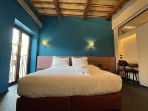 a bedroom with a large bed with a blue wall at Passpartout Boutique Palace in Rome