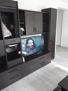 - un centre de divertissement noir avec une télévision dans l'établissement Apartament b&b Rădăuți, à Rădăuţi
