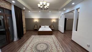 een slaapkamer met een bed en een tapijt bij Lite Guest House in Bisjkek