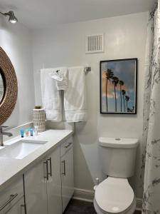 uma casa de banho branca com um WC e um lavatório em ROYAL COLONIAL em Boca Raton