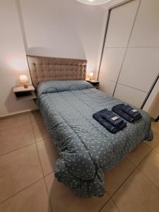 1 dormitorio con 1 cama con 2 toallas azules en Departamento Entero con Pileta Calasanzs en Córdoba
