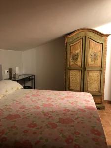 a bedroom with a bed and a wooden cabinet at Il Nido Del Cuculo in Carrara