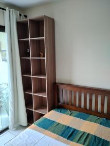 a bedroom with a bed and a book shelf at Gravatá - Flat Fazenda Monte Castelo in Sairé