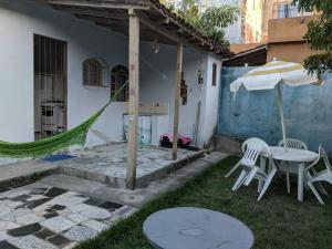 un patio con mesa, sillas y sombrilla en Kitnet Recanto do Bem-te-vi, en Jacaraípe
