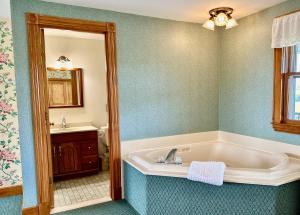 een badkamer met een bad en een wastafel bij Rose Farm Inn in New Shoreham