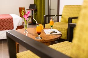 - deux verres de jus d'orange sur une table dans une chambre d'hôtel dans l'établissement ONOMO Hotel Bamako, à Bamako