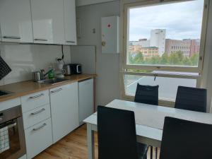 a kitchen with a table and chairs and a window at apartment in great location in Helsinki