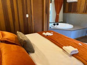 y baño con 2 camas y bañera. en Hotel Cabanas Glamour, en Gramado