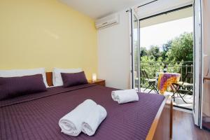 a bedroom with a purple bed with towels on it at Apartments Villa Borik in Rovinj