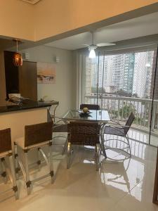 una cucina e una sala da pranzo con tavolo e sedie di Apartamento four seasons a Guarujá