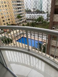 balcone con vista su una piscina blu di Apartamento four seasons a Guarujá
