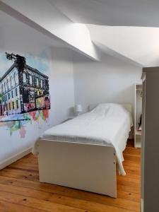 um quarto com uma cama branca e um quadro na parede em OLOPO no Porto