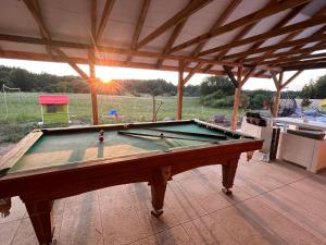 a pool table on a patio with a roof at Koniec Świata domek z basenem in Stare Sady