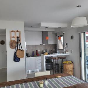 a kitchen with white cabinets and a table and chairs at Departamento Miranda in Villa Gesell