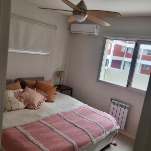 a bedroom with a bed with a ceiling fan at Departamento Miranda in Villa Gesell +20 photos