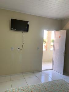 um quarto com uma televisão de ecrã plano na parede em Pousada Jesus Me Deu em Iguatu