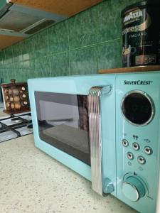 a blue microwave sitting on a counter in a kitchen at Entire apartment in Pakruojis in Pakruojis