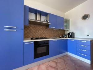 kuchnia z niebieskimi szafkami i piekarnikiem w obiekcie Scalea Apartments & Pool w mieście Scalea