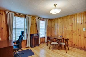 ein Esszimmer mit Holzwänden sowie einem Tisch und Stühlen in der Unterkunft Historic Augusta Getaway with Screened Porch! in Augusta