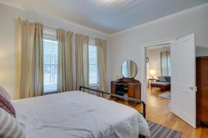 a bedroom with a bed and a chair and a mirror at Historic Augusta Getaway with Screened Porch! in Augusta