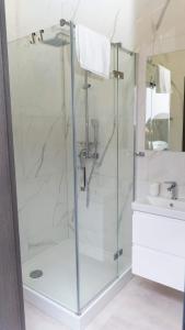 een douche met een glazen deur in de badkamer bij Bon Żur in Brzeg