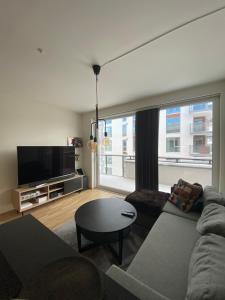 a living room with a couch and a tv at Ny og moderne 2-roms leilighet på Øvre Nyhavna in Trondheim