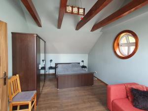 a bedroom with a bed and a couch and a mirror at Apartamenty Wałowa 11 in Leszno