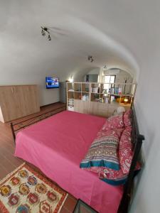 a bedroom with a large pink bed in a room at La casina in città - The little flat in town in Alessandria