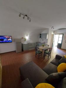 a living room with a table and a kitchen at La casina in città - The little flat in town in Alessandria