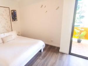 Résidence Prestige, Calme & Terrasse Ensoleillée في غرونوبل: غرفة نوم بيضاء بها سرير ونافذة