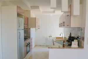 une cuisine avec des placards blancs et un comptoir dans l'établissement Apt 5min de la zone touristique, à Hammamet