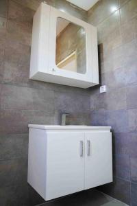 a bathroom with a white sink and a mirror at Apt 5min de la zone touristique avec piscine Residence Jude in Hammamet +17 photos