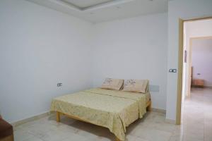 1 dormitorio con 1 cama en una habitación blanca en Apt 5min de la zone touristique en Hammamet