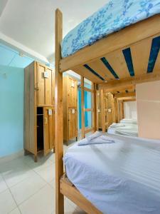 a bedroom with two bunk beds and wooden cabinets at Hostel Samara in Sámara