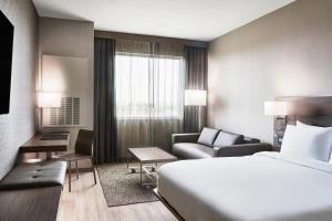 una camera d'albergo con letto e divano di AC Hotel by Marriott Miami Airport West/Doral a Miami